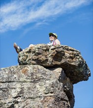 Low angle view of woman sitting on rock
