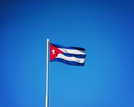 Cuba, Havana, Cuban flag with blue sky