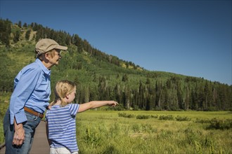 USA, Utah, Lake City, Girl (4-5) with grandmother standing on boardwalk by wetland