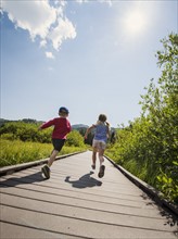 Children (4-5) running on boardwalk