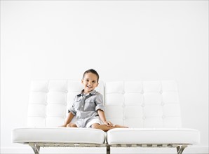 Portrait of boy (2-3) sitting on white sofa