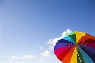 Low angle view of colorful beach umbrella against sky