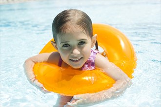 Portrait of girl (4-5) swimming in inflatable ring