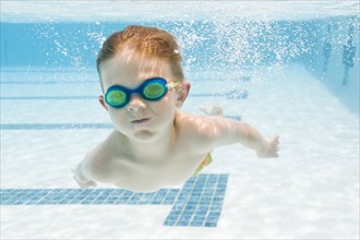 Boy (6-7) swimming in pool