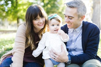 Portrait of parents with daughter (12-17 months) in park