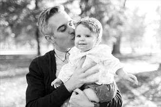 Father kissing daughter (12-17 months)
