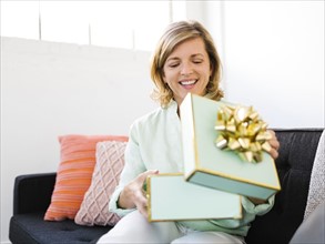 Mature woman opening gift