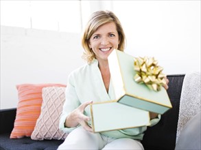 Portrait of Mature woman opening gift