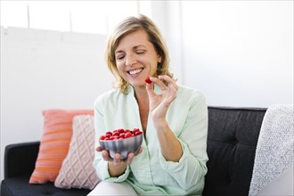 Mature woman eating raspberries
