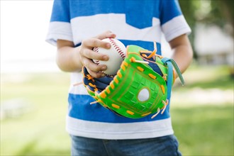 Mid section of boy (6-7) holding baseball ball