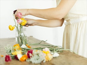 Woman putting flowers into jar
