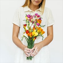 Woman holding bouquet of freesias