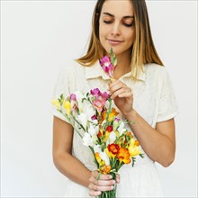 Portrait of woman smelling bouquet of freesias