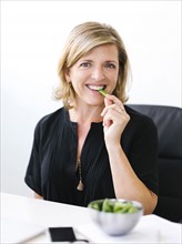 Woman eating green peas