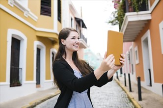 Puerto Rico, San Juan, Woman with tablet doing selfie on city street