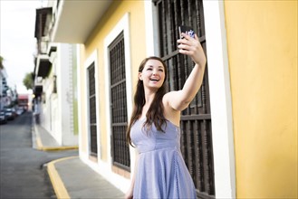Puerto Rico, San Juan, Beautiful woman doing selfie on city street