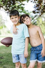 Young boys (6-7, 8-9) with american football ball