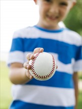 Young boy (6-7) holding baseball ball