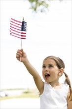 Girl (4-5) holding american flag