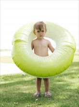 Boy (2-3) standing with inflatable ring