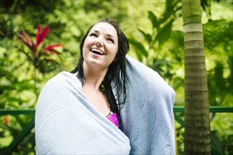 Caribbean Islands, Saint Lucia, Woman with wet hair wrapped in towel with lush foliage in background