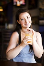 Portrait of woman drinking juice in cafe