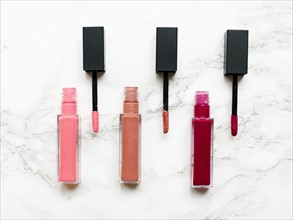 Lip glosses on marble background