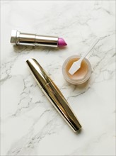 Lipstick and mascara on marble background
