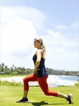 USA, Hawaii, Kauai, Woman exercising on beach