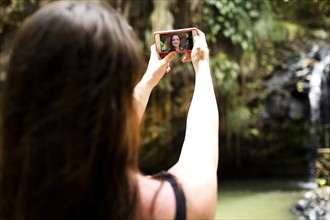 Saint Lucia, Woman taking selfie in front of waterfalls