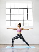 Woman practicing yoga on exercise mat