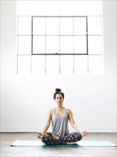 Woman meditating on exercise mat