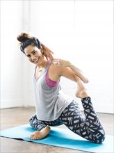 Portrait of woman stretching on exercise mat