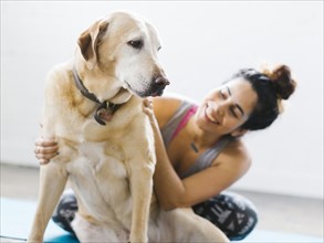 Woman practicing yoga with dog