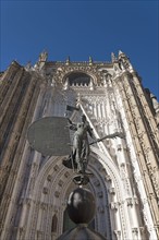 Spain, Andalusia, Seville, Giralda Tower with sculpture presenting faith in foreground