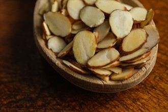 Close-up of wooden spoon full of sliced almonds on table