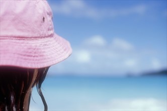 Mature woman in pink sun hat on Caribbean beach