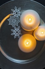 Three candles and Christmas ornaments on tray