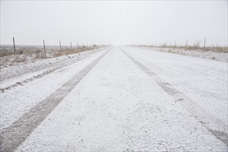 USA, Colorado, Empty dirt road covered with snow