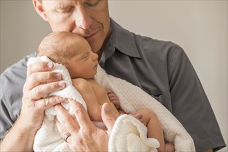 Father embracing newborn son (0-1 month)