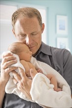 Father embracing newborn son (0-1 month)