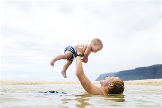 USA, Hawaii, Kauai, Father with baby boy (12-17 months) playing in sea