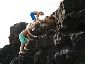 USA, Hawaii, Kauai, Boys (4-5, 8-9) climbing on rocks