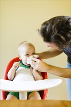 Father assisting son (12-17 months) to blow nose