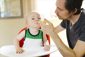 Father applying medicine to son (12-17 months)