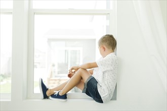 Boy (7-8) looking through window