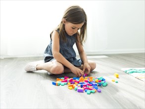 Girl (6-7) playing with plastic blocks