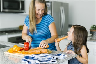 Mother cooking with daughter (6-7) in kitchen