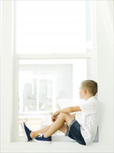 Boy (6-7) looking through window