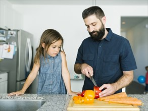 Father with daughter (6-7) cooking together